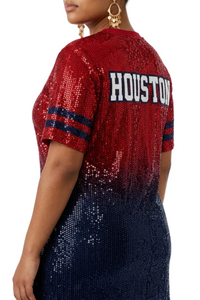 A woman wearing a short-sleeve sequined top with a red-to-navy ombre gradient and 'HOUSTON' printed across the back in white letters with a navy outline.